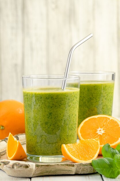 Foto batido verde saludable con espinacas, mango, naranja, lima, manzana, citrone en frascos de vidrio.