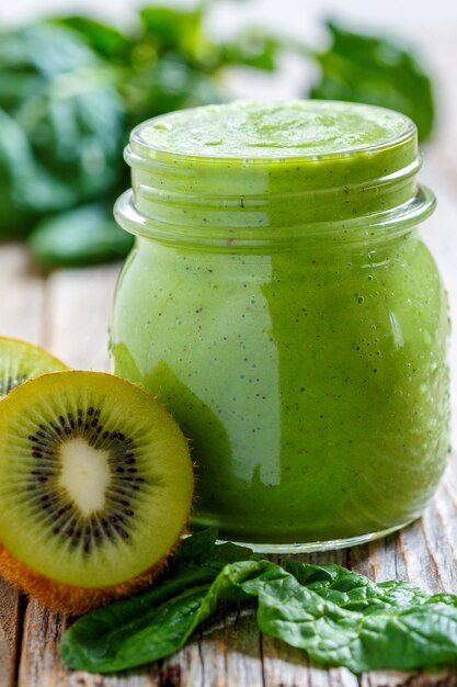 Batido verde saludable en tarro de espinacas y kiwi de cerca