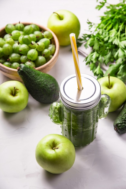 Batido verde en un vaso con forma de cactus entre los ingredientes verdes