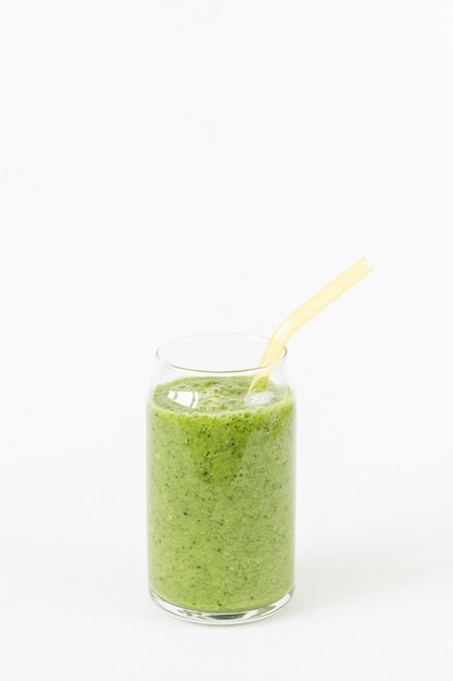 Batido verde en vaso con pajita de vidrio ecológica Fondo blanco Vegano crudo limpio saludable