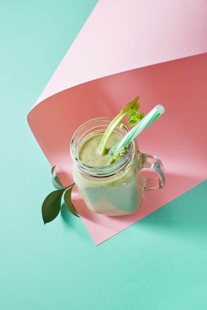 Batido verde de verduras orgánicas con espárragos y apio en un recipiente de vidrio en duotono