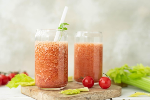 Batido de verduras frescas de tomates y apio en un tarro de cristal