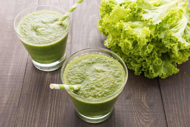 Batido de verduras y frutas verdes saludables en la mesa de madera rústica