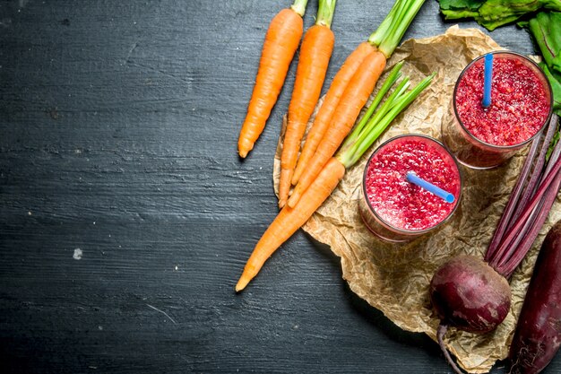 Batido de verduras con remolacha y zanahorias sobre fondo negro