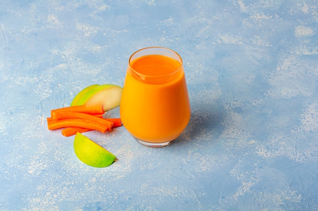 Batido de zanahoria desintoxicante nutritivo. Bebida vegetariana orgánica y rodajas de zanahorias y manzana verde. Concepto de alimentación saludable Nutrición adecuada, concepto de dieta de fitness. Jugo de naranja en un vaso.