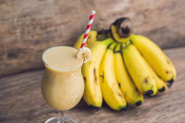 Batidos de banana e bananas em um velho fundo de madeira