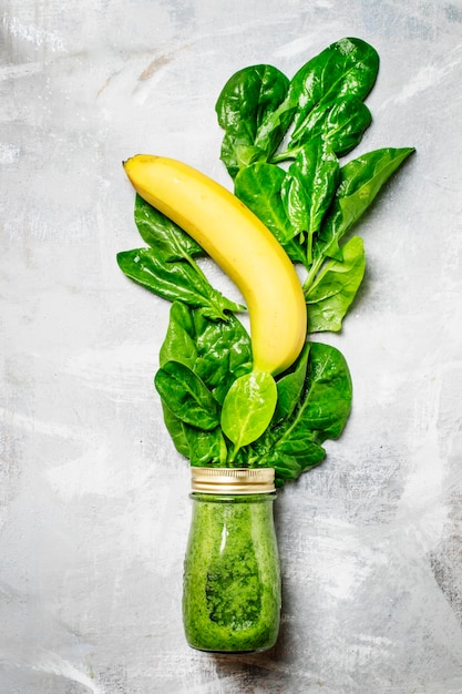 Batidos de desintoxicación verdes hechos de hojas de espinacas en una botella de vidrio vista superior fondo de alimentos