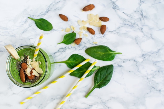 Batidos de espinacas verdes en frasco con semillas de chía, nueces almendras, concepto de comida saludable