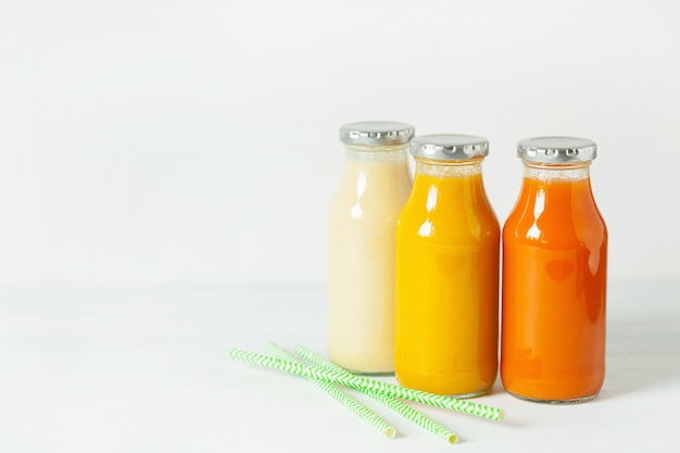 Batidos de frutas y verduras en botellas de vidrio.