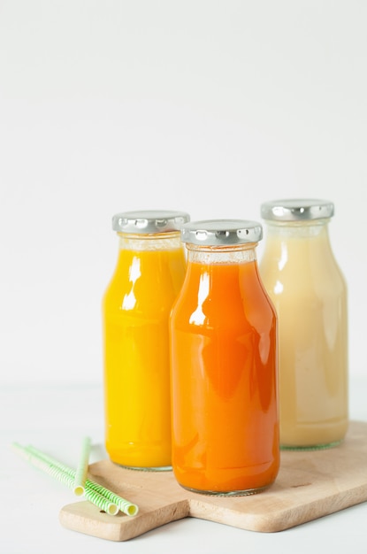 Batidos de frutas y verduras en botellas de vidrio.