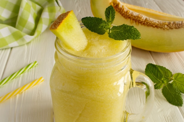 Batidos de melón en el fondo de madera blanca