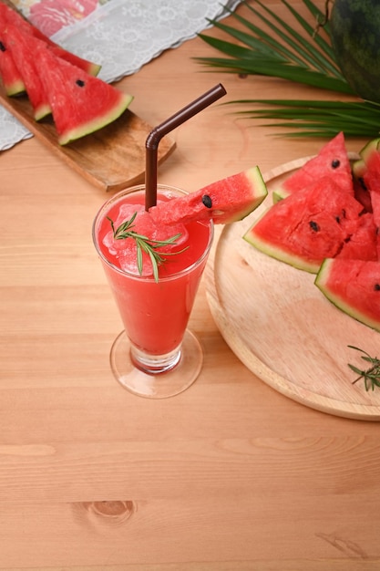 Batidos de sandía con sandía fresca cortada en una mesa de madera. Concepto de bebidas de verano.