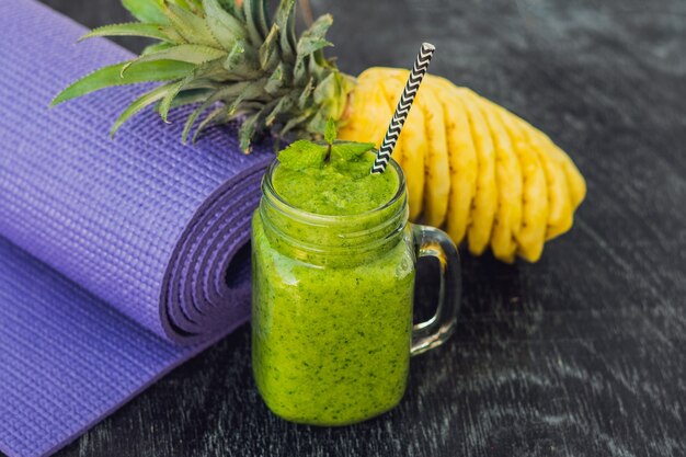 Batidos verdes hechos de espinacas y piña y una esterilla de yoga