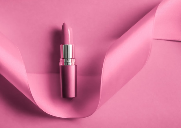 Batom de luxo e fita de seda em maquiagem de fundo de férias rosa e flatlay de cosméticos para design de produto de marca de beleza