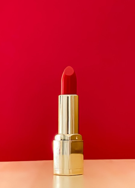 Batom vermelho em tubo dourado na cor de fundo maquiagem de luxo e cosméticos para design de produto de marca de beleza