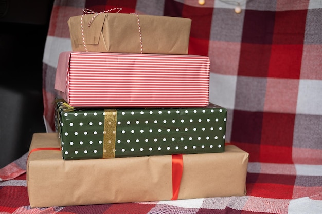 Baú de carro cheio de caixas de presente, presentes e guirlanda para férias de Natal. floresta ao ar livre