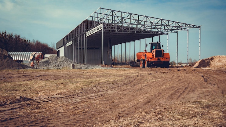Foto bau eines großen hangars auf dem land mit hilfe schwerer maschinen.