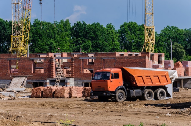 Bau eines kleinen vorstädtischen backsteinhauses. baumaschine.