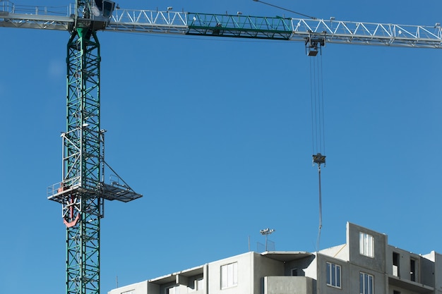 Bau eines Wohnhochhauses. Foto eines Baukrans, der Bodendecks installiert.