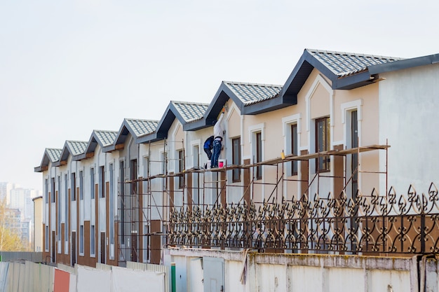 Bau moderner Gebäude. Meister arbeiten an der Fertigstellung des Hauses