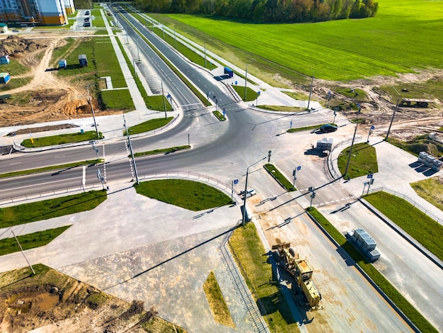 Bau neuer Straßen und Gehwege in der Stadtansicht von oben Drohnenfotografie Verbesserung des Geländes und der Zufahrtsstraßen Straßenarbeiten von oben Straßenkreuzung