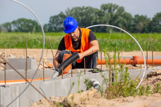 Bau- oder Bauleiter, der die Fundamente des neuen Hauses, Gebäudes oder Baus überprüft oder überwacht