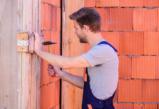 Bau- und Konstruktionsingenieur mit Hammerwerkzeug Allgemeine Wartungs- und Reparaturarbeiter werden für Wartungs- und Reparaturaufgaben eingestellt. Verwenden Sie einen Hammerarbeiter mit Hammermauerhintergrund