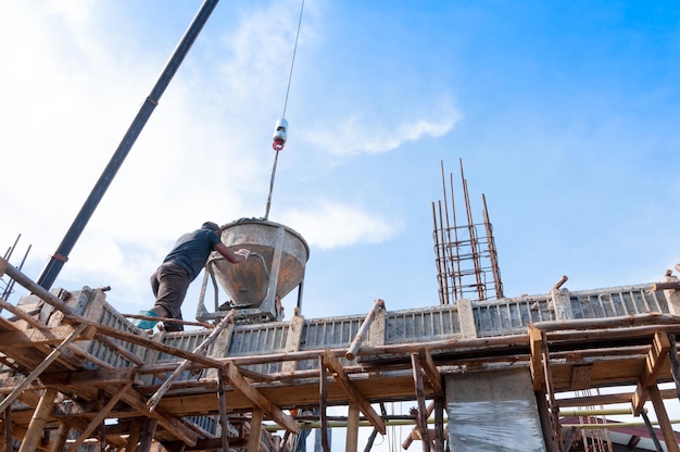 Bauarbeiter auf der Baustelle gießen Beton in formMan Arbeiten in der Höhe