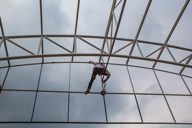 Bauarbeiter bauen Gerüste auf und streichen Dachkonstruktionen.