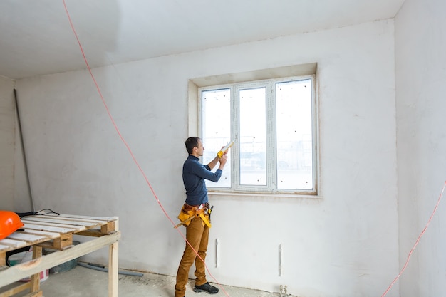 Bauarbeiter, der Fenster im Haus einbaut