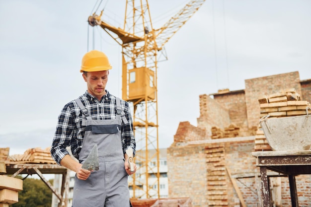 Bauarbeiter in Uniform und Sicherheitsausrüstung haben Arbeit am Bau