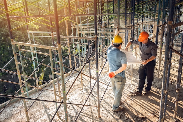 Foto bauarbeiteringenieur mit zwei geschäftsleuten, effektsonneaufflackern