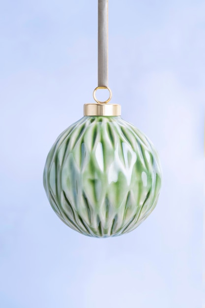 Bauble verde cerâmico do Natal em um fundo claro