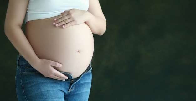 Bauch der Schwangerschaftsfrau mit Handgriff