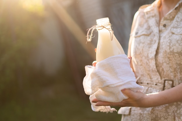 Bauer, der eine frische natürliche Milch in Flaschen hält