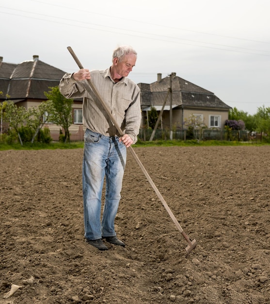 Bauer, der im Frühling im Garten arbeitet