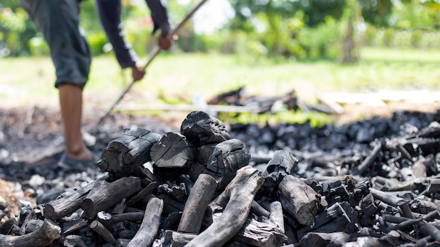Bauern verbrennen Holzkohle aus Holz, das von der Farm abgeschnitten wurde