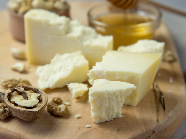 Bauernkäse serviert mit Honig und Nüssen auf hellem Hintergrund. Platz kopieren