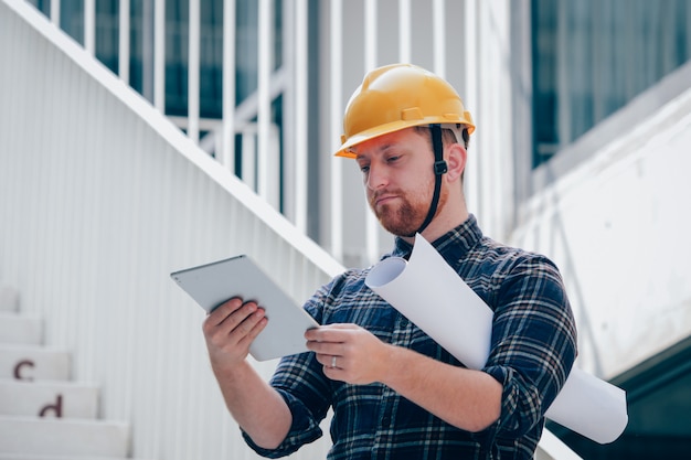 Bauingenieur, der an Baustelle mit Computer arbeitet