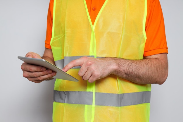 Bauingenieur des jungen Mannes mit Tablette auf hellgrauem Hintergrund