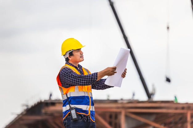 Bauingenieur überprüft Projekt auf der Baustelle Architekt mit Blaupausen auf einer Baustelle Vorarbeiter mit Hardhat auf der Infrastrukturbaustelle