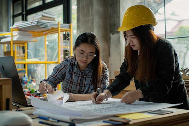 Bauingenieure in Aktion Architektin und Geschäftsfrau am Schreibtisch mit Bauplänen