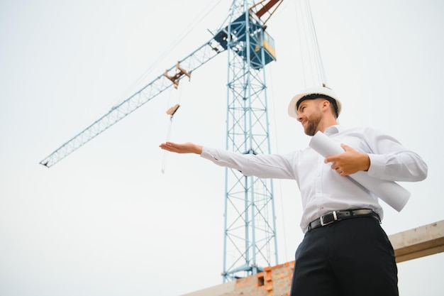 Baukonzept des Ingenieurs, der auf der Baustelle mit Blaupause arbeitet