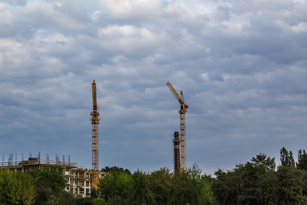 Baukräne am bewölkten Himmel