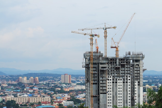 Baukräne, die an Gebäude arbeiten