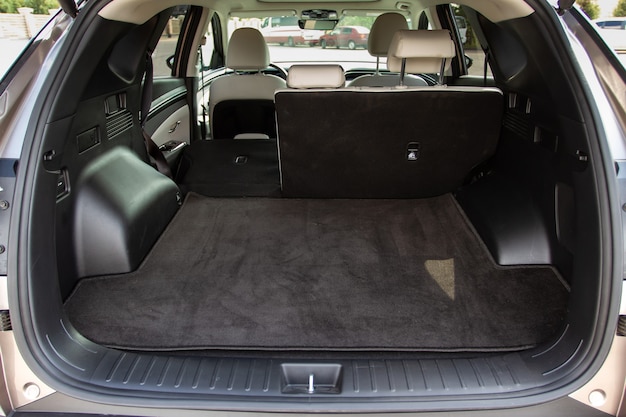 Baúl de coche enorme, limpio y vacío de un todoterreno compacto moderno. Vista trasera de un automóvil SUV con maletero abierto y un asiento plegado. Interior del maletero del coche.