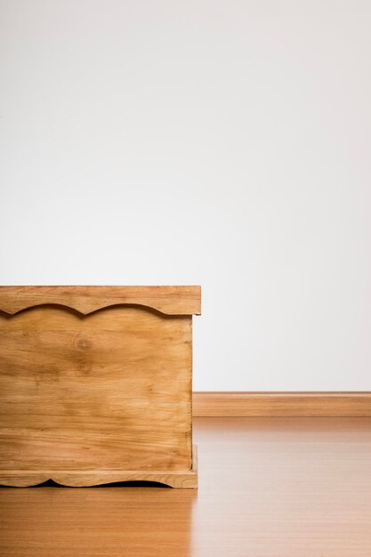 Baúl de madera sobre fondo blanco y piso de madera | Foto Premium