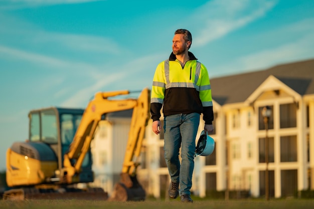 Baumeister auf Bagger Bauarbeiter mit Bagger Bauarbeiter mit Helm Bauarbeiter mit Bauarbeiterhelm Porträt mech