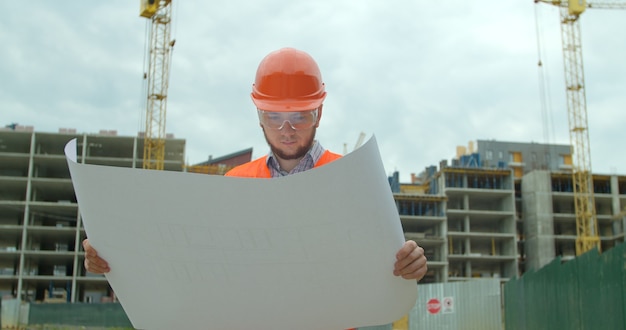 Baumeister, der vor dem im Bau befindlichen Gebäude steht