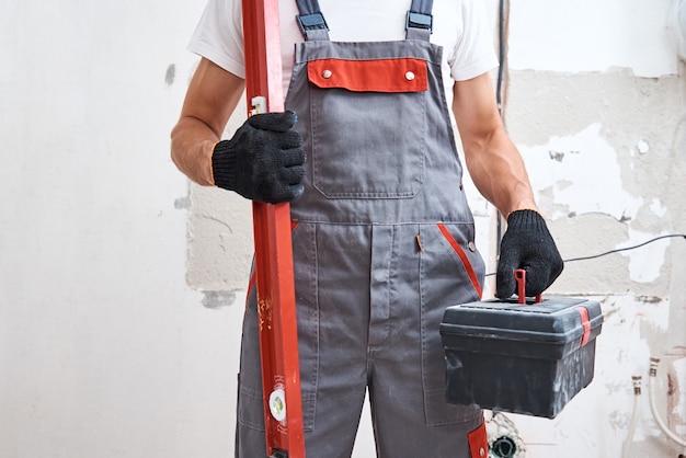Baumeister in Uniform mit einem Bauwerkzeug. Reparaturkonzept